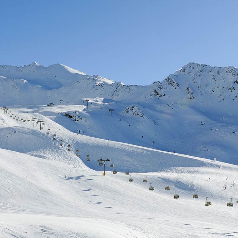 Panorama Skipiste vor Berglandschaft